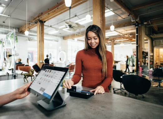 Smiling Woman Standing at a POS System